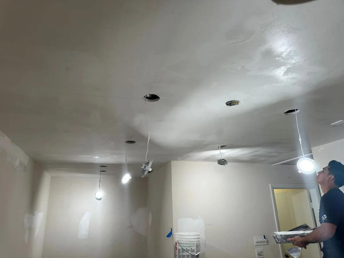 Home Xperts 360 crew member finishing ceiling drywall repairs before painting