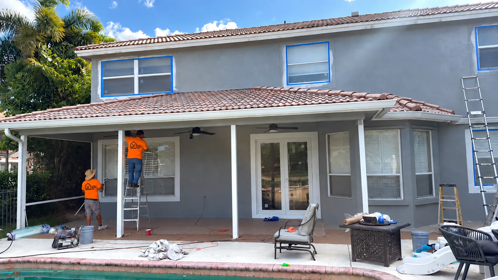 Painters masking and painting a home exterior