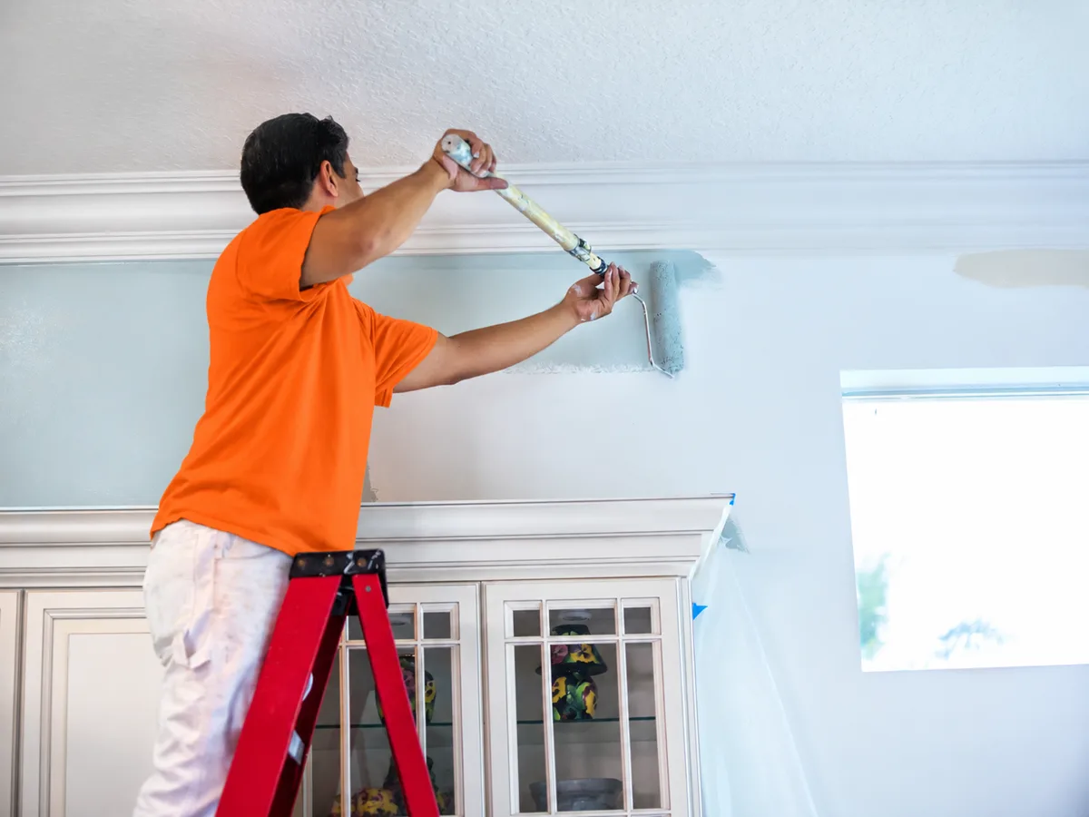 Painter rolling an interior wall