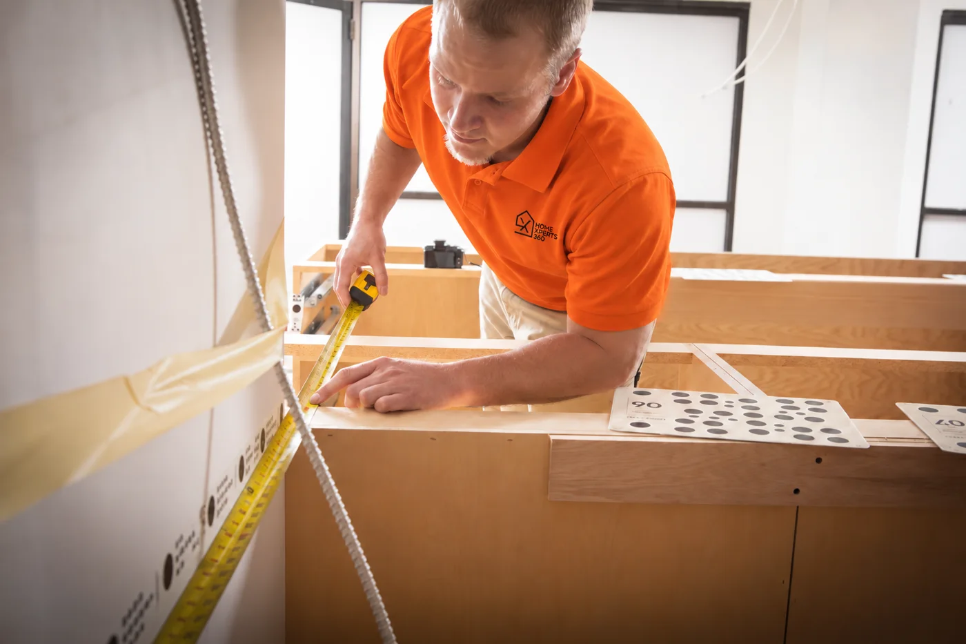 Home Xperts 360 installer measuring new kitchen cabinets for countertops