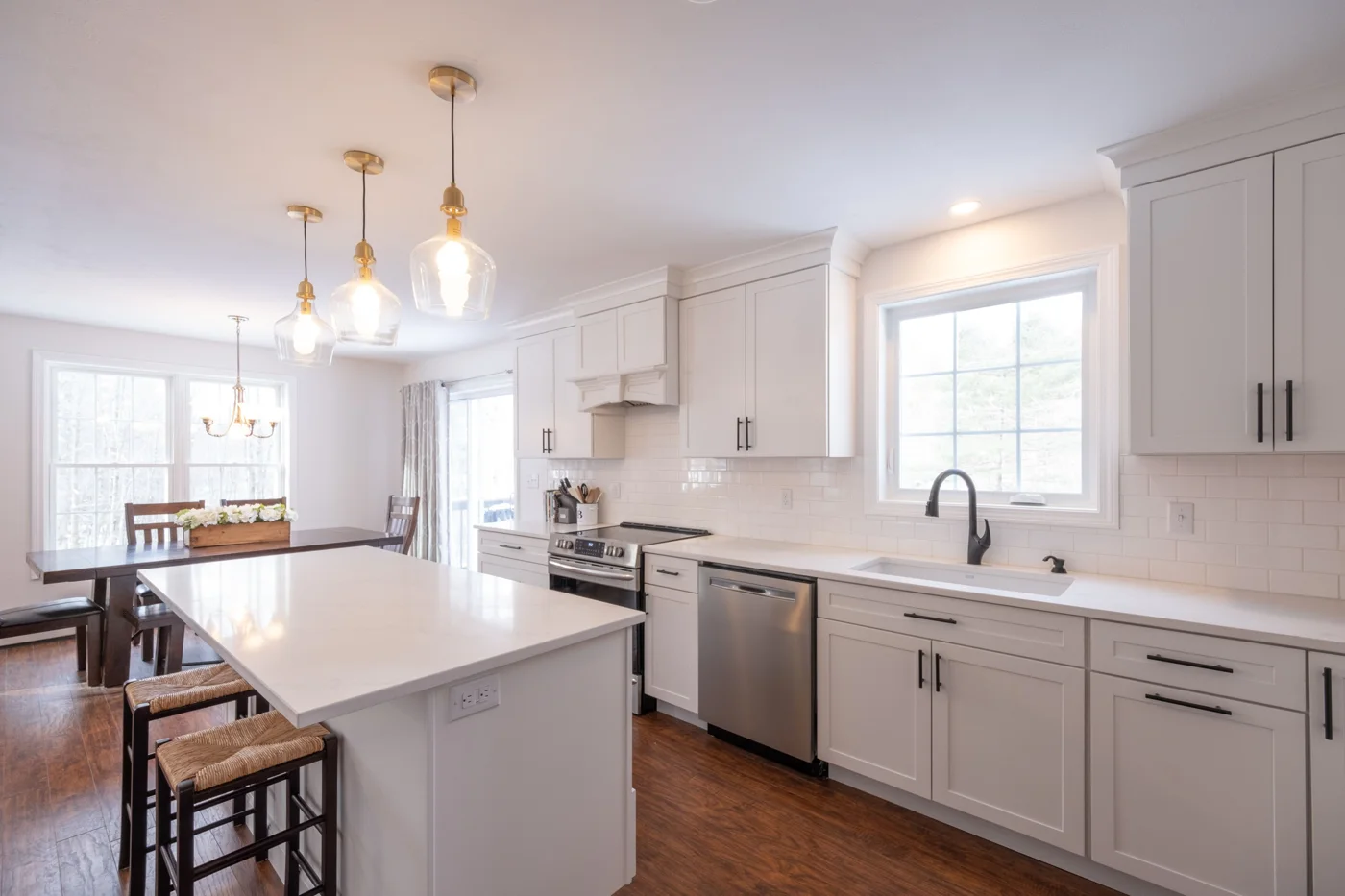 White shaker kitchen with quartz island and pendant lights